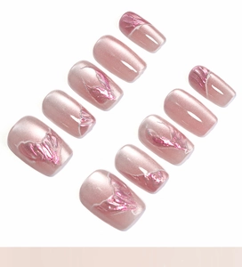 Detailed view of pink cat-eye press-on nails with silver-purple metallic wing texture