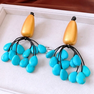 Close-up of vintage tassel earrings featuring gold metal drops and turquoise stone beads