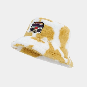 Close-up of plush bucket hat with cow print and retro tape recorder embroidery patch