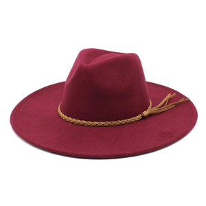 Detail of burgundy wool fedora hat featuring a brown braided leather belt with fringe decor