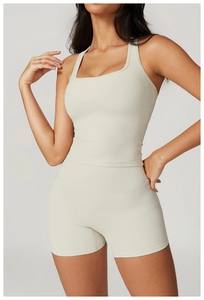 Detailed view of high-elastic fabric texture on cream sports vest and matching shorts