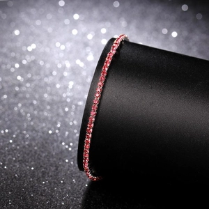 Macro detail of elastic red crystal rhinestone bracelet on a black jewelry stand