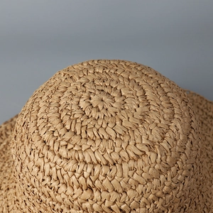 Macro shot of the tight radial weaving pattern on a khaki handmade paper straw sun hat