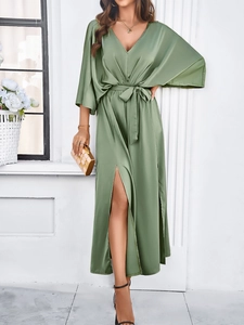 Detail of green satin midi dress featuring a V-neckline, belted waist and front slit design