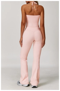 Rear view of pink halter backless crop top and flared high-waisted yoga pants set