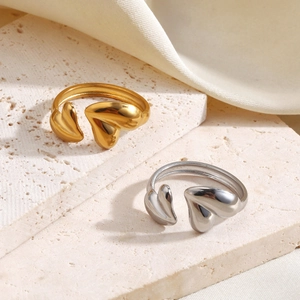 Minimalist 18K gold and silver heart open rings set on neutral textured stone