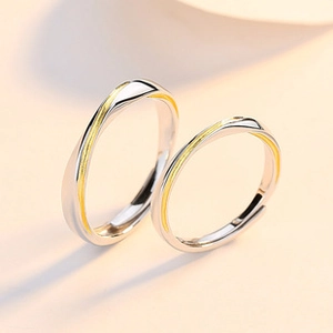 Detail view of silver couple rings with gold wave line and adjustable open band design