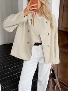 Detail of beige double-breasted jacket with brown buttons and professional loose fit style