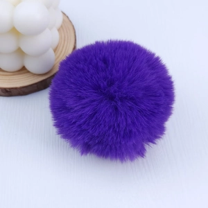 Close-up of a 8cm dark purple faux rabbit fur pom pom with soft and dense texture