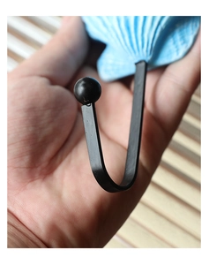 Macro view of a blue seashell resin wall hook with black metal J-shaped hanger