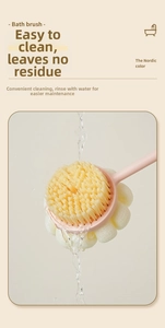 Close-up of dual-sided bath brush with soft bristles and mesh sponge in pink handle