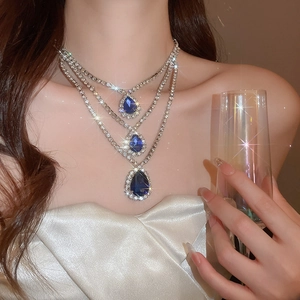 Dettaglio dell'elegante collana a tre strati in argento con ciondoli a goccia blu brillante