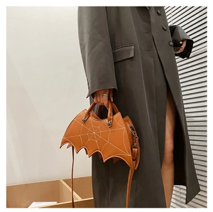 Close-up of brown PU leather bat-shaped handbag featuring white spider web embroidery detail