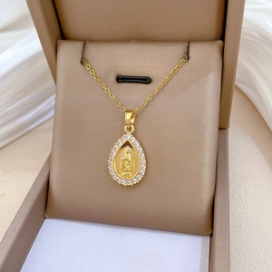 Macro shot of gold teardrop necklace featuring Virgin Mary relief and zircon halo