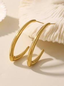 Gros plan de boucles d'oreilles goutte en C plaquées or 18K avec finition miroir poli