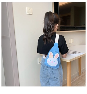 Detail of blue canvas rabbit chest bag for kids with pink sequined ears and wide strap