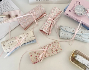 Roll-up floral fabric makeup pouch with pink ribbon tie and soft inner lining