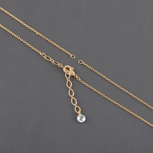 Detailed close-up of the 18k gold lobster clasp with an adjustable chain and crystal bead