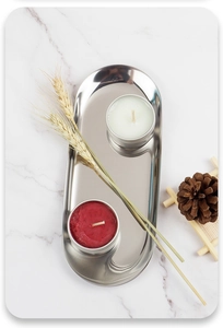 Vertical top view of silver stainless steel oval tray with candles on marble surface