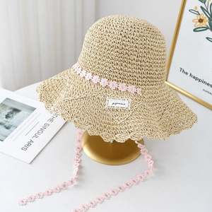 Handwoven straw hat with pink floral lace trim and long ties for beach sun protection