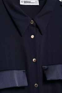 Close-up of navy blue dress with satin pockets and gold buttons on the front