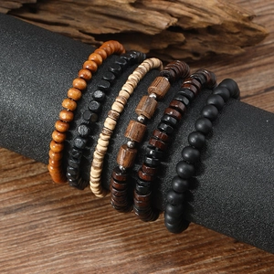 Detailed close-up of six layered handmade wooden bead bracelets on a black display
