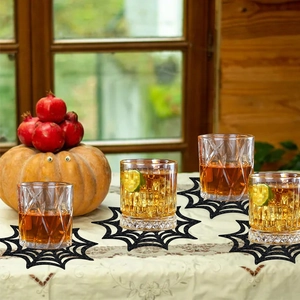Set of four black spider web coasters under glass cups for Halloween table decor