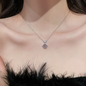 Detail of rose gold necklace with pink zircon floral pendant worn on the collarbone