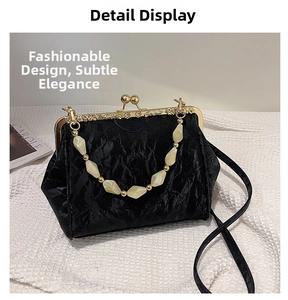 Detail of black pleated shell bag with vintage gold metal clasp and pearl beaded handle