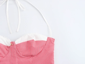 Detailed close-up of a striped halter mini dress with white thin straps and open back