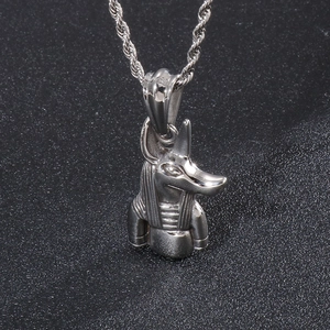 Macro shot of silver Anubis jackal head pendant with twisted rope chain on dark background