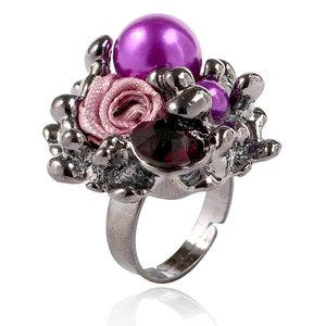 Détail de bague réglable avec perles violettes, rose en tissu et pierre rouge facettée