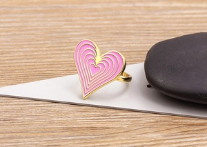 Macro shot of 18K gold plated ring featuring a pink gradient oil drip heart design