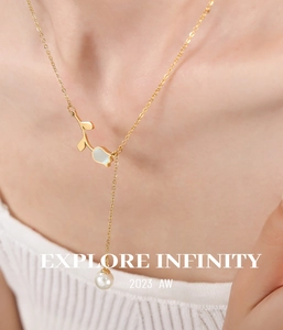 Detailed view of a 18K gold Y-necklace with tulip shell pendant and round pearl on neck