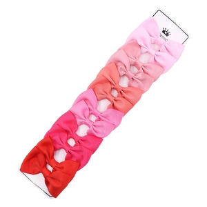 Close-up of 10-piece grosgrain ribbon bow hair clips set on display card in red gradients