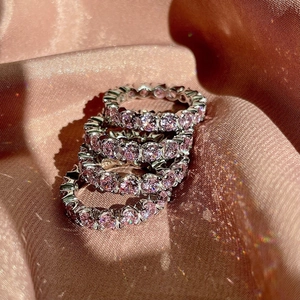 Close-up of four stacked S925 silver rings featuring round-cut pink eternity zircons