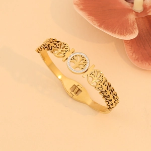 Gold-tone tree of life bangle with crystal embellishments and hollow leaf pattern