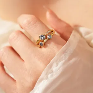Bague double rangée dorée vintage avec pièces et zircons sur une main élégante