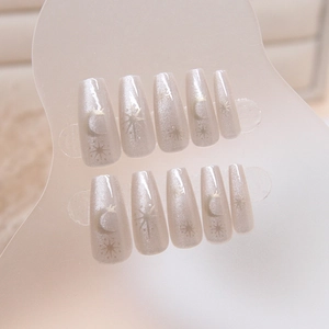 Cat eye press-on nails set with golden moon and star patterns on pearly silver base