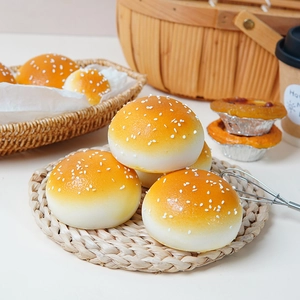 Realistic slow rebound burger bun stress toy with sesame seeds on a woven mat