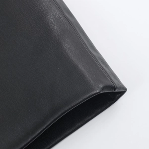 Close-up of the premium black leather texture and fine grain on this winter coat detail