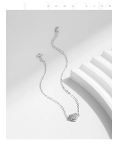 Detail of s925 silver heart bracelet with sparkling pavé stones on stone stairs background