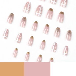 Pink press-on nails with gold French tips, plaid patterns and glitter accents