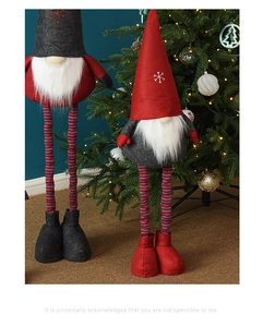 Detail of Christmas gnomes with long striped legs and tall hats near a festive tree