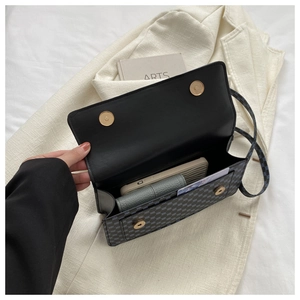 Detail of grey monogram crossbody bag interior showing storage for phone and wallet