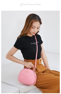 Detail showing pink diamond quilted semi-circle bag with golden chain and top handle