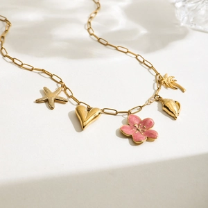 Detail of 18K gold stainless steel chain with pink flower and beach-themed pendants