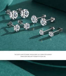 Dettaglio macro di orecchini a perno in argento 925 con zirconi scintillanti e montatura a griffe