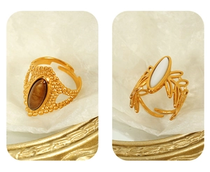 Detail of vintage gold open rings with tiger eye stone and leaf patterns on a tray