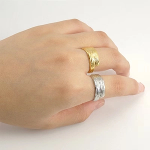 Textured gold and silver titanium steel open rings with elegant wave pattern on model hands